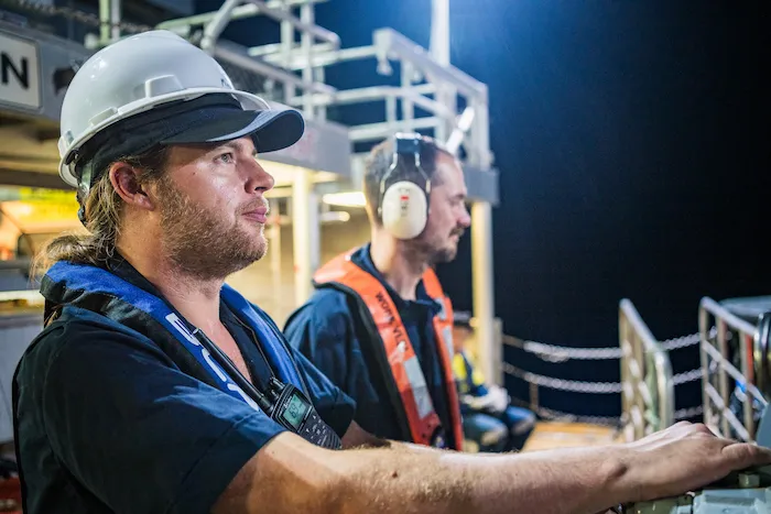 wassoc subsea engineer operating winch on back of ship at night