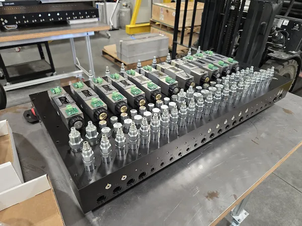 subsea hydraulic manifold being assembled on a shop bench